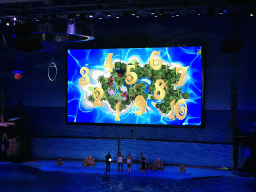 Dolphin and zookeepers in the Main Hall of the Pole Aquarium at the Dalian Laohutan Ocean Park, during the Water Show