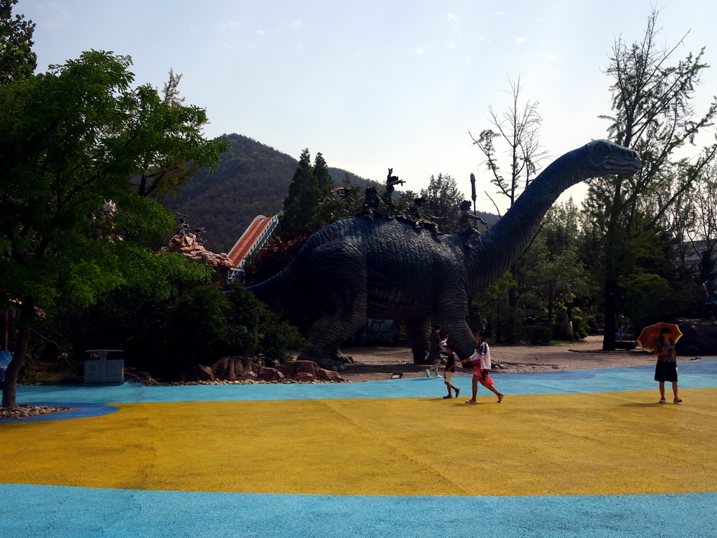 Dinosaur and cavemen statues at the Jurassic Exploration area at the Dalian Laohutan Ocean Park