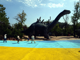 Dinosaur and cavemen statues at the Jurassic Exploration area at the Dalian Laohutan Ocean Park