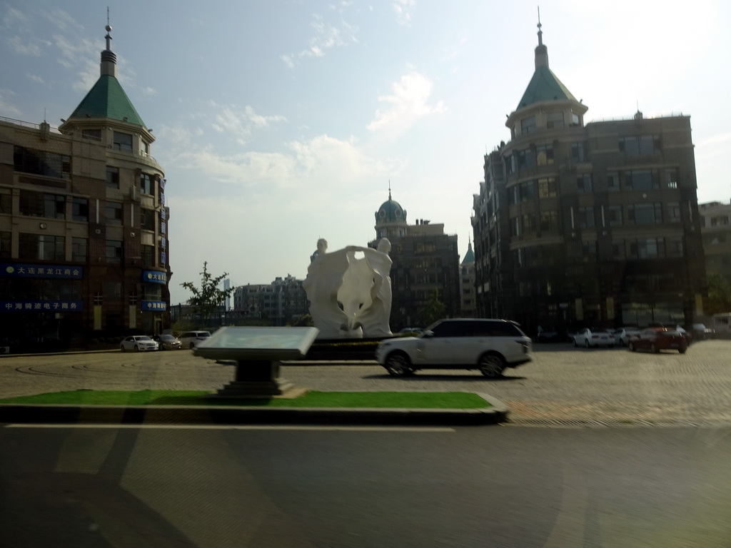 Statue and buildings at Binhai West Road, viewed from the taxi