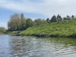 The Singelgracht canal and a fisherman at the Bossche Broek grassland, viewed from the tour boat