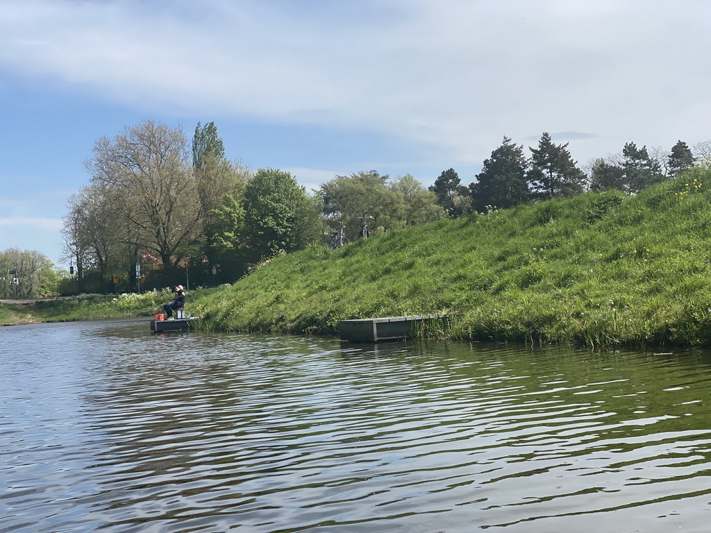 The Singelgracht canal and a fisherman at the Bossche Broek grassland, viewed from the tour boat