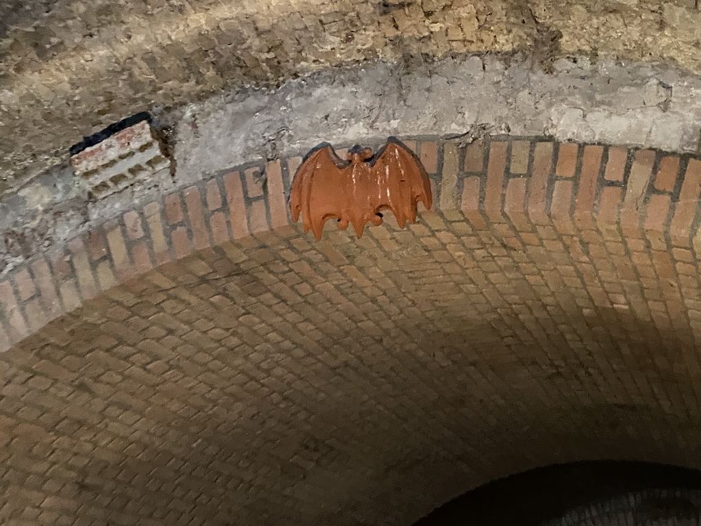 Statue of a bat in a tunnel at the Binnendieze canal, viewed from the tour boat