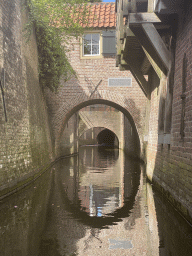 Building and bridge over the Binnendieze canal at the Beurdsestraat street, viewed from the tour boat