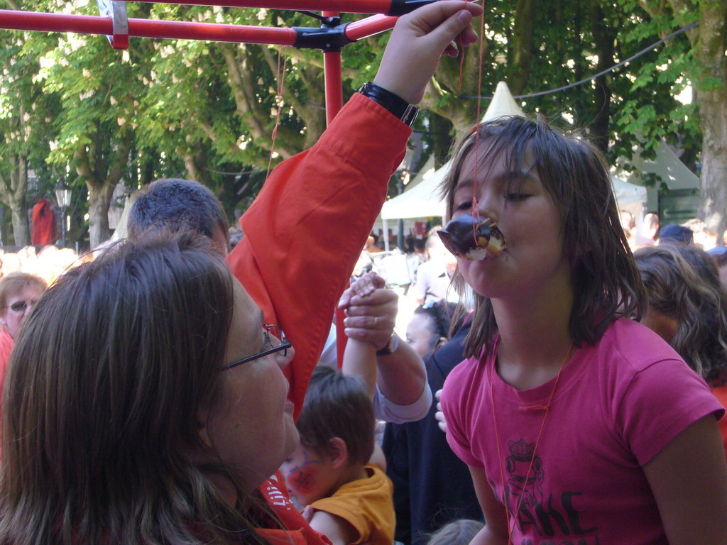 Child eating a `Bossche bol` during the Queen`s Day festivities at the Parade square