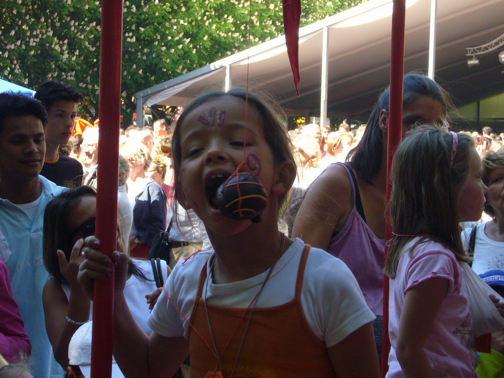 Child eating a `Bossche bol` during the Queen`s Day festivities at the Parade square