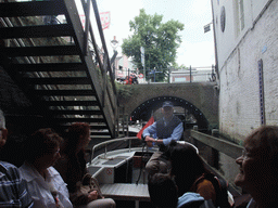 Our tour boat with the guide in the Binnendieze river at the boarding point of the boat tour at the Molenstraat street