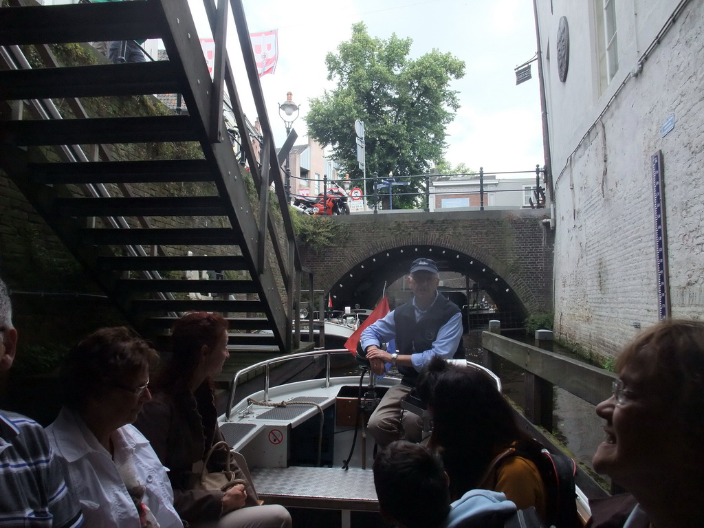 Our tour boat with the guide in the Binnendieze river at the boarding point of the boat tour at the Molenstraat street