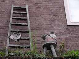 Ladder and stool with bucket at a house at the Binnendieze river, viewed from the tour boat