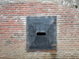 Gate in a wall at the Binnendieze river, viewed from the tour boat