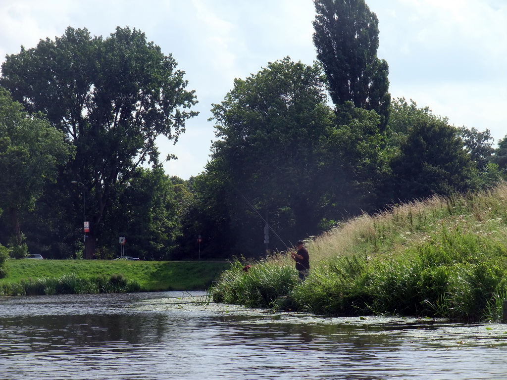 Fisherman at the Bossche Broek grassland, viewed from the tour boat on the Singelgracht canal