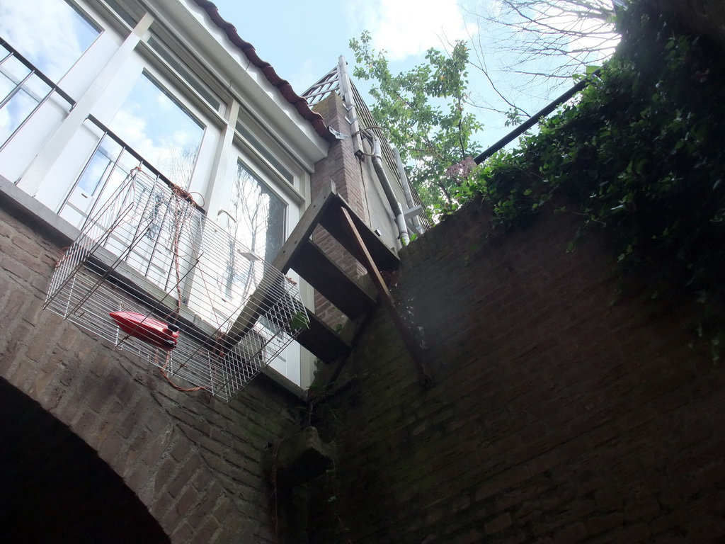 Staircase from a building over the Binnendieze river to its garden, viewed from the tour boat