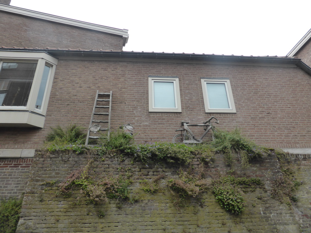 Ladder, stool with bucket and bicycle at a house at the Binnendieze river, viewed from the tour boat