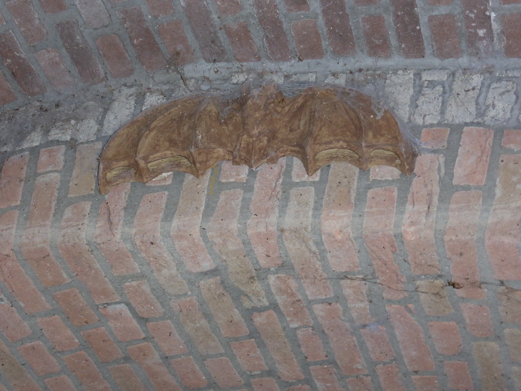 Statue of a bat in a tunnel at the Binnendieze canal, viewed from the tour boat