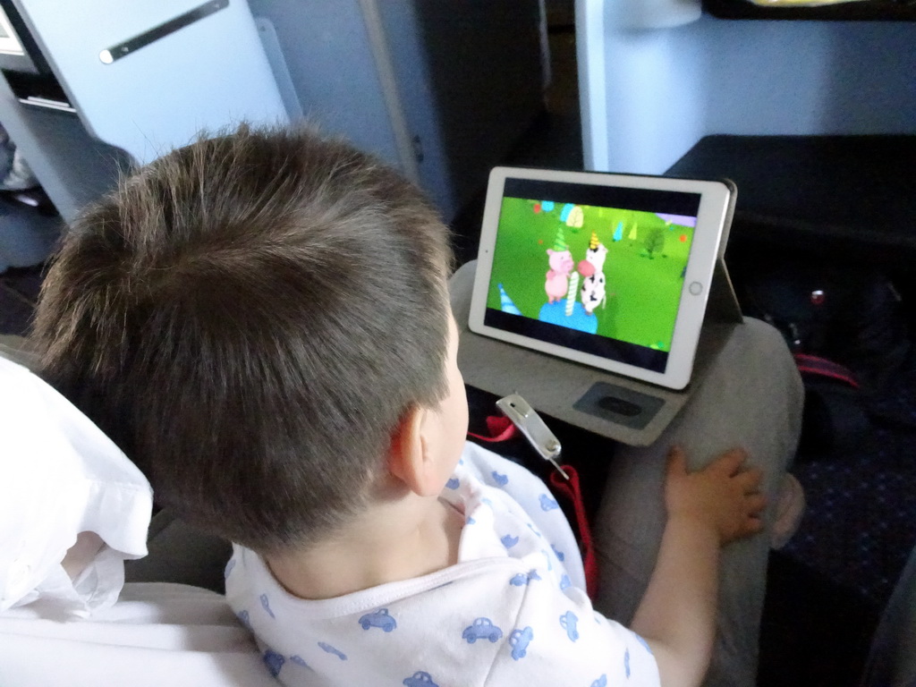 Max watching TV in the airplane from Amsterdam to Singapore