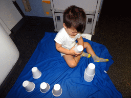 Max playing with plastic cups in the airplane from Singapore to Amsterdam
