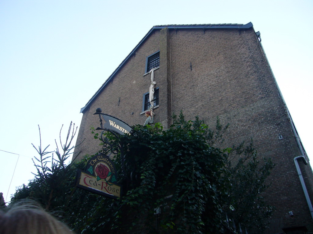 Statue hanging from a window at the Wallstreet Tea-Rose lunchroom at the Walstraat street