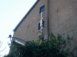 Statue hanging from a window at the Wallstreet Tea-Rose lunchroom at the Walstraat street