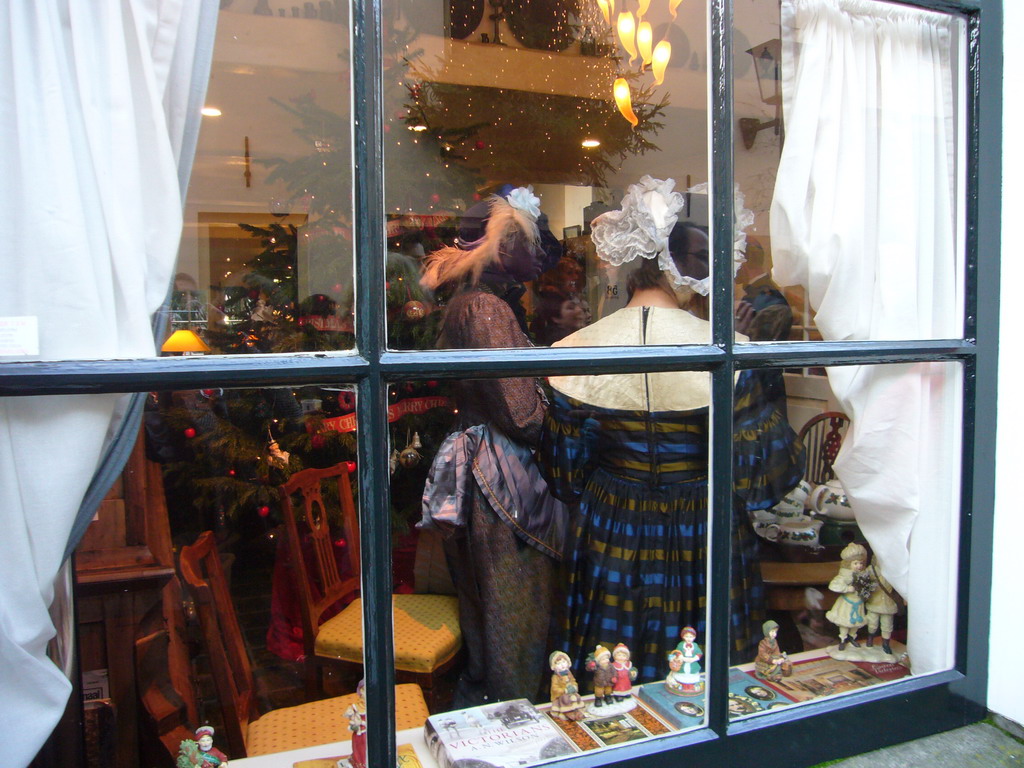 Actors in Victorian clothing in the window of a shop at the Walstraat street, during the Dickens Festival