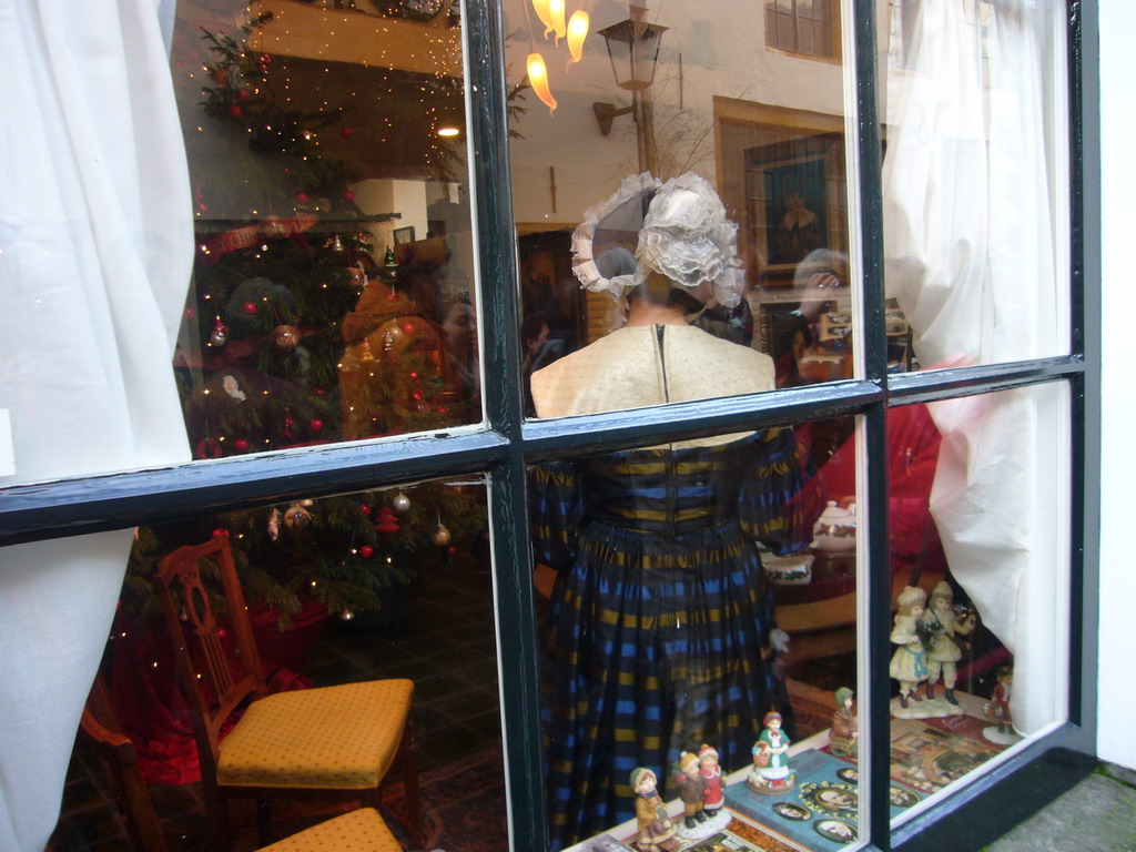 Actors in Victorian clothing in the window of a shop at the Walstraat street, during the Dickens Festival