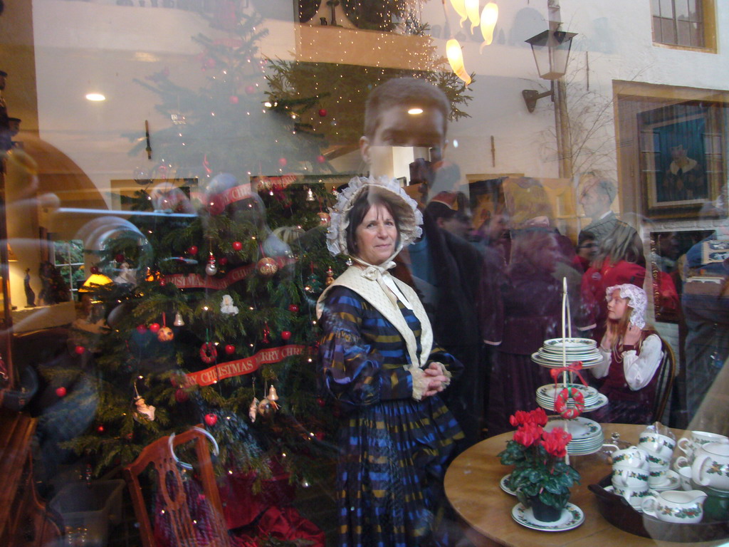 Actors in Victorian clothing in the window of a shop at the Walstraat street, during the Dickens Festival