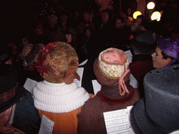 Actors in Victorian clothing singing at a square in the city center, during the Dickens Festival, at sunset