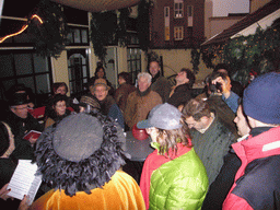 Actors in Victorian clothing singing at a square in the city center, during the Dickens Festival, at sunset