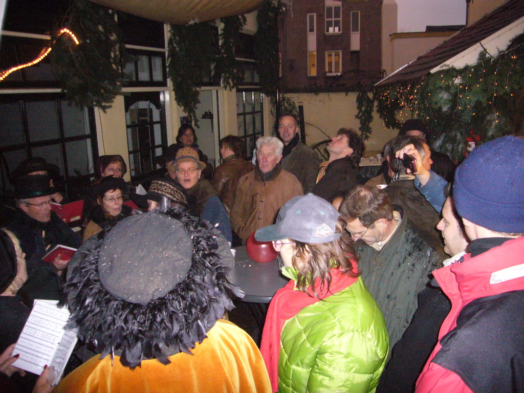 Actors in Victorian clothing singing at a square in the city center, during the Dickens Festival, at sunset