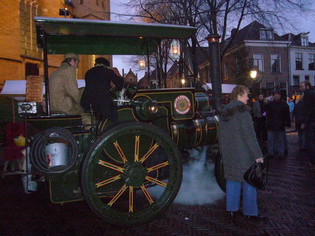 Old locomotive in front of the St. Nicholas Church at the Bergkerkplein square, during the Dickens Festival parade, at sunset