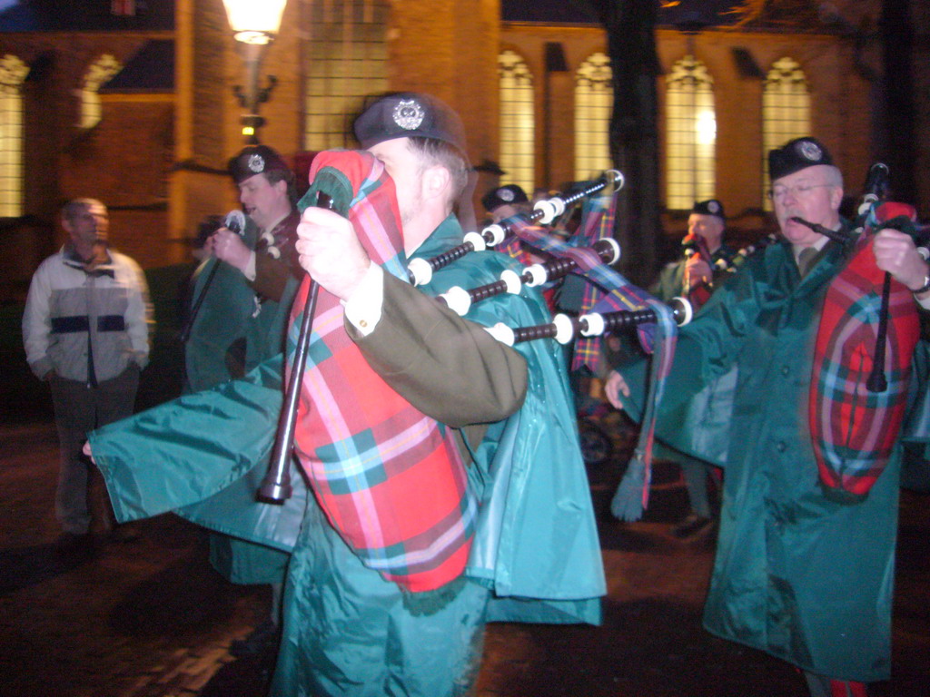 Bagpipe players in front of the St. Nicholas Church at the Bergkerkplein square, during the Dickens Festival parade, by night