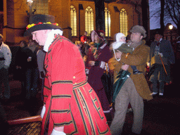 Actors in Victorian clothing in front of the St. Nicholas Church at the Bergkerkplein square, during the Dickens Festival parade, by night