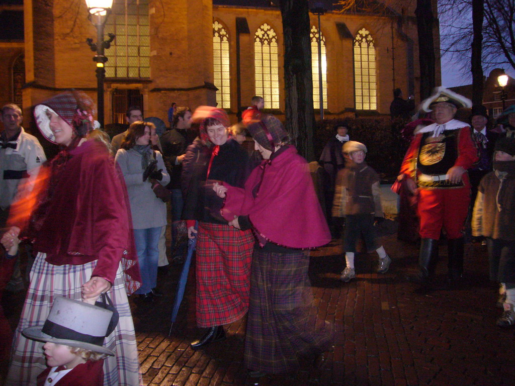 Actors in Victorian clothing in front of the St. Nicholas Church at the Bergkerkplein square, during the Dickens Festival parade, by night