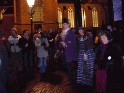 Actors in Victorian clothing in front of the St. Nicholas Church at the Bergkerkplein square, during the Dickens Festival parade, by night