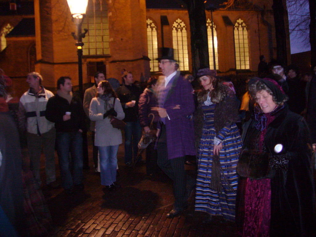 Actors in Victorian clothing in front of the St. Nicholas Church at the Bergkerkplein square, during the Dickens Festival parade, by night