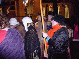 Actors in Victorian clothing in front of the St. Nicholas Church at the Bergkerkplein square, during the Dickens Festival parade, by night