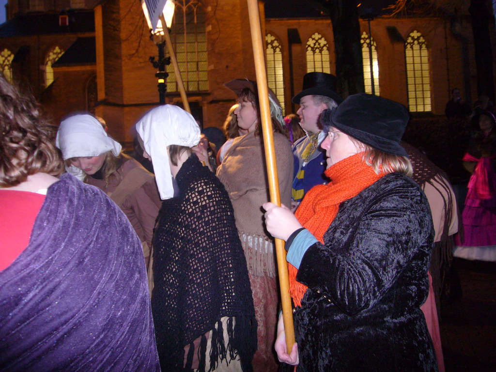 Actors in Victorian clothing in front of the St. Nicholas Church at the Bergkerkplein square, during the Dickens Festival parade, by night