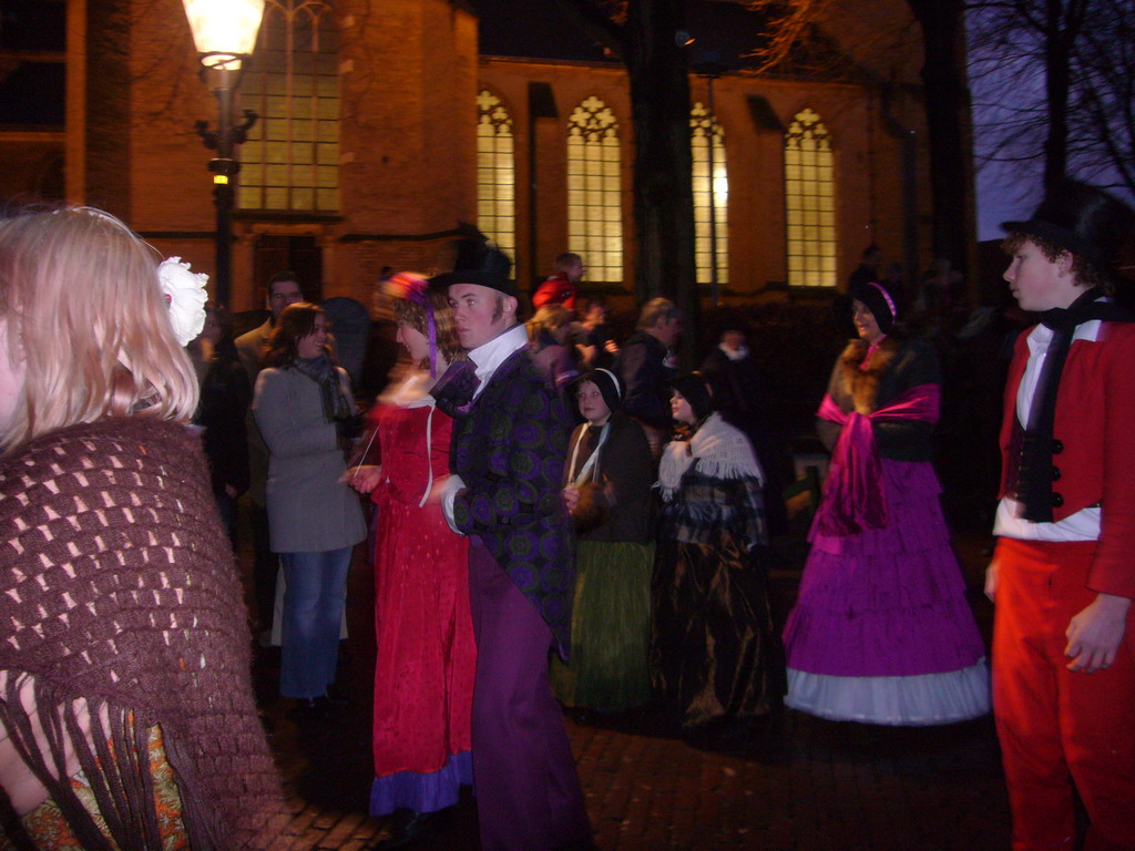 Actors in Victorian clothing in front of the St. Nicholas Church at the Bergkerkplein square, during the Dickens Festival parade, by night