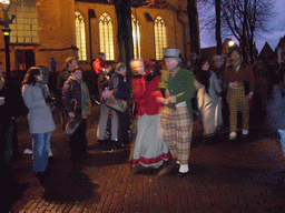 Actors in Victorian clothing in front of the St. Nicholas Church at the Bergkerkplein square, during the Dickens Festival parade, by night