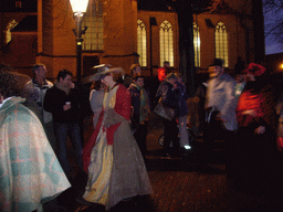 Actors in Victorian clothing in front of the St. Nicholas Church at the Bergkerkplein square, during the Dickens Festival parade, by night