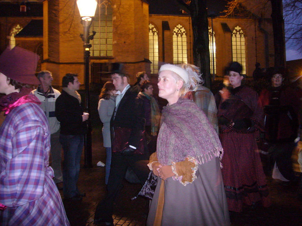 Actors in Victorian clothing in front of the St. Nicholas Church at the Bergkerkplein square, during the Dickens Festival parade, by night