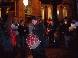 Drummer and actors in Victorian clothing in front of the St. Nicholas Church at the Bergkerkplein square, during the Dickens Festival parade, by night