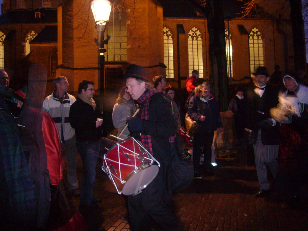 Drummer and actors in Victorian clothing in front of the St. Nicholas Church at the Bergkerkplein square, during the Dickens Festival parade, by night