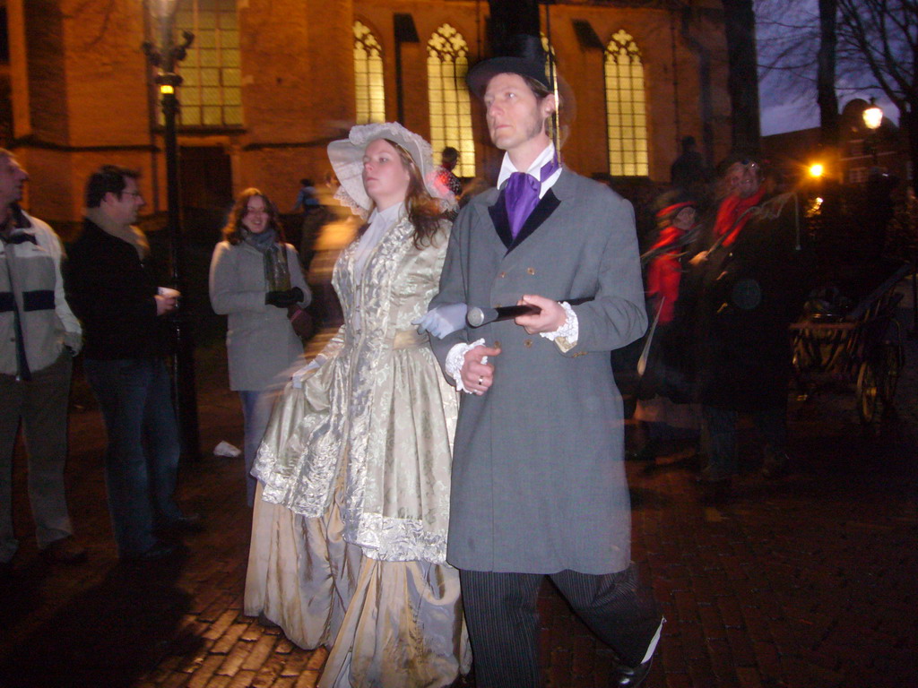 Actors in Victorian clothing in front of the St. Nicholas Church at the Bergkerkplein square, during the Dickens Festival parade, by night