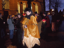 Actors in Victorian clothing in front of the St. Nicholas Church at the Bergkerkplein square, during the Dickens Festival parade, by night