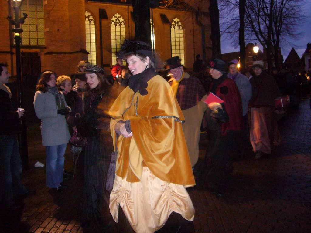 Actors in Victorian clothing in front of the St. Nicholas Church at the Bergkerkplein square, during the Dickens Festival parade, by night