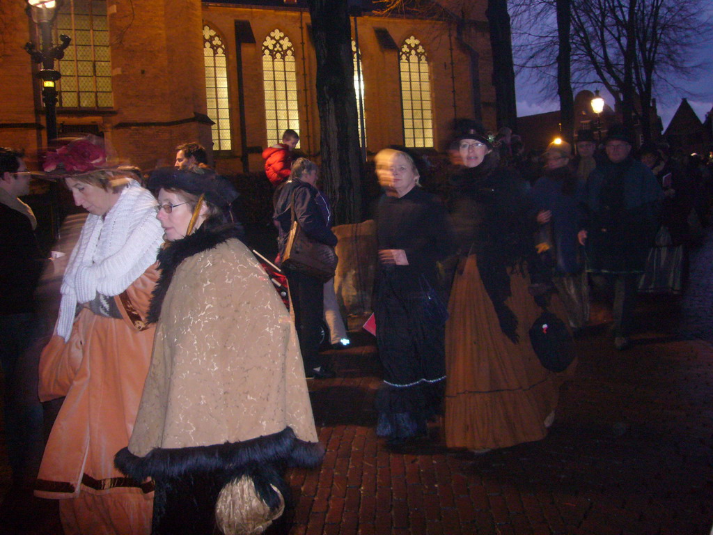 Actors in Victorian clothing in front of the St. Nicholas Church at the Bergkerkplein square, during the Dickens Festival parade, by night