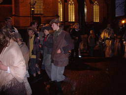 Actors in Victorian clothing in front of the St. Nicholas Church at the Bergkerkplein square, during the Dickens Festival parade, by night