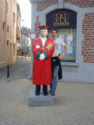 Tim with a statue of the Brotherhood of Dinant Puff Pastry Tart Eaters at the Place Saint-Nicolas square