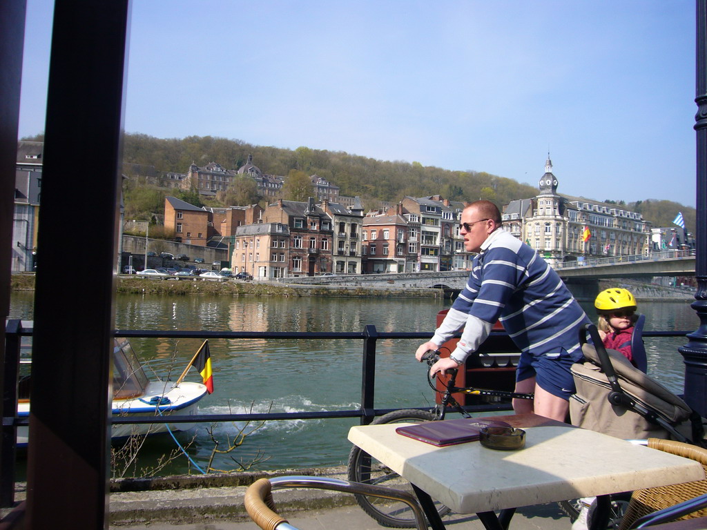 Cyclist at the Avenue Winston Churchill and a boat in the Meuse river, viewed from the terrace of the Le Galion restaurant