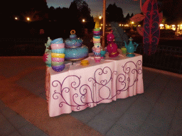 Table with tableware at the Mad Hatter`s Tea Cups attraction at Fantasyland at Disneyland Park, by night